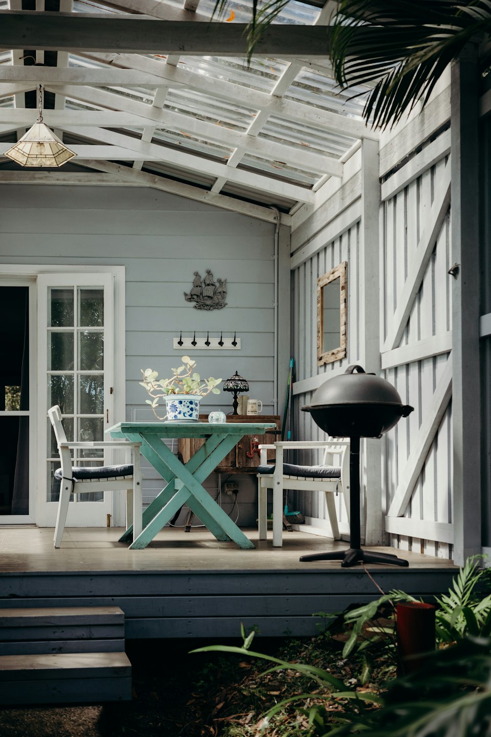 Covered patio with table, chairs, and barbecue.
